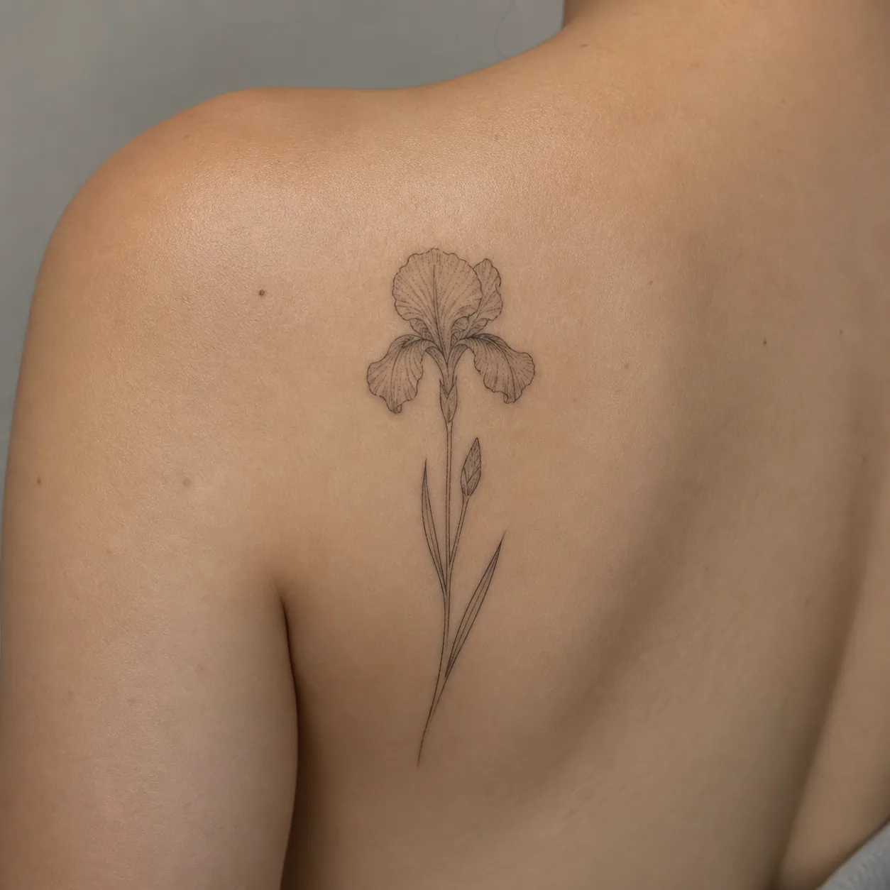 Botaniczny tatuaż irysa na łopatce